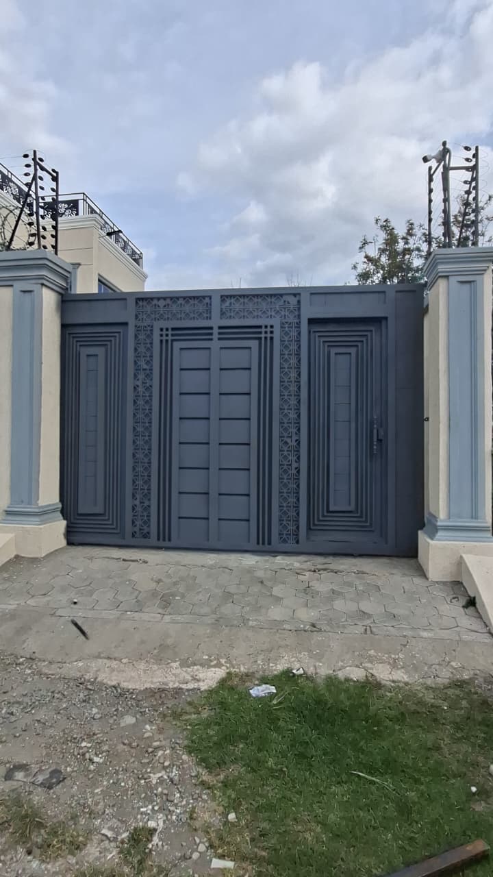 Black steel driveway gate with gold decorative details