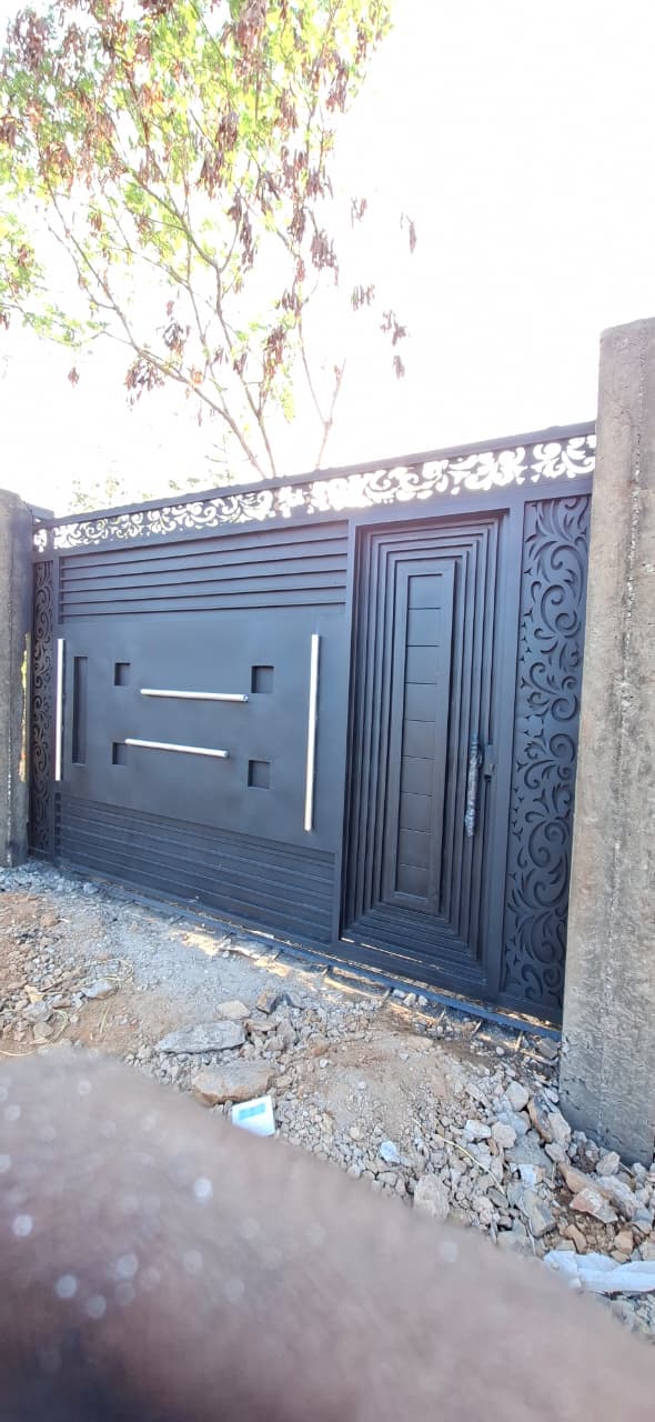 Black steel driveway gate with gold decorative details