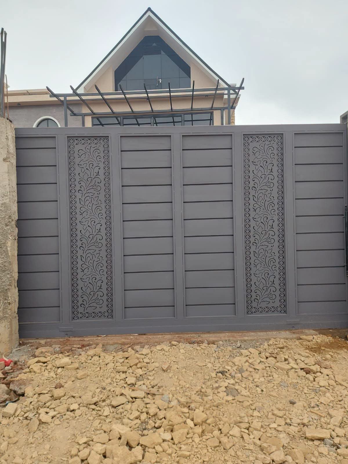 Black steel driveway gate with gold decorative details