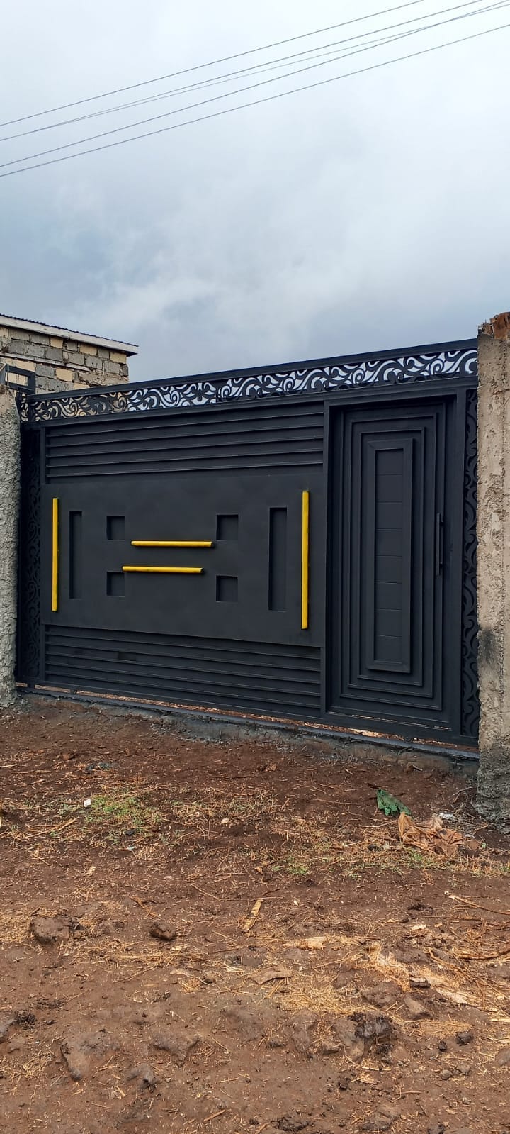 Black steel driveway gate with gold decorative details