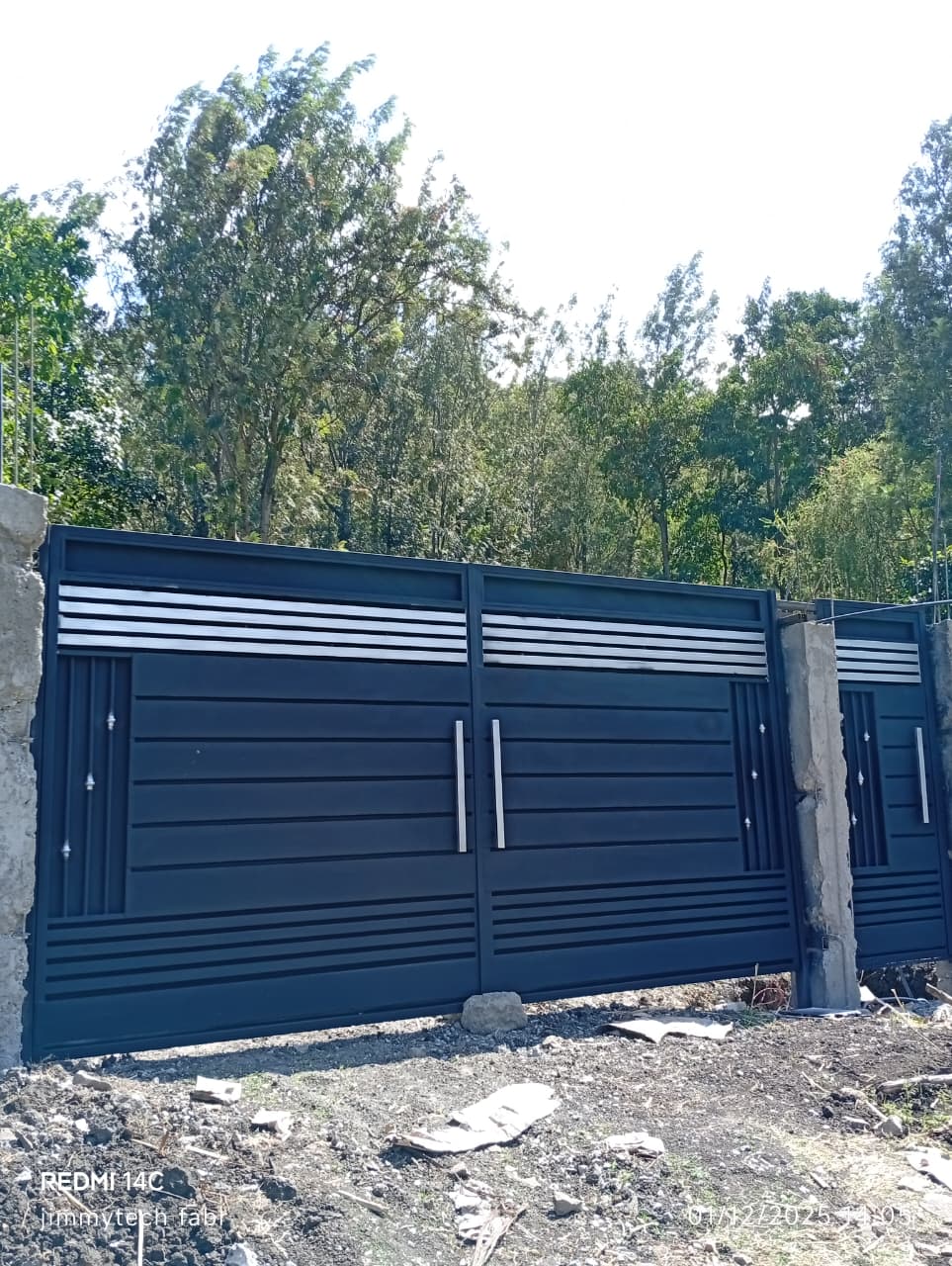 Black steel driveway gate with gold decorative details