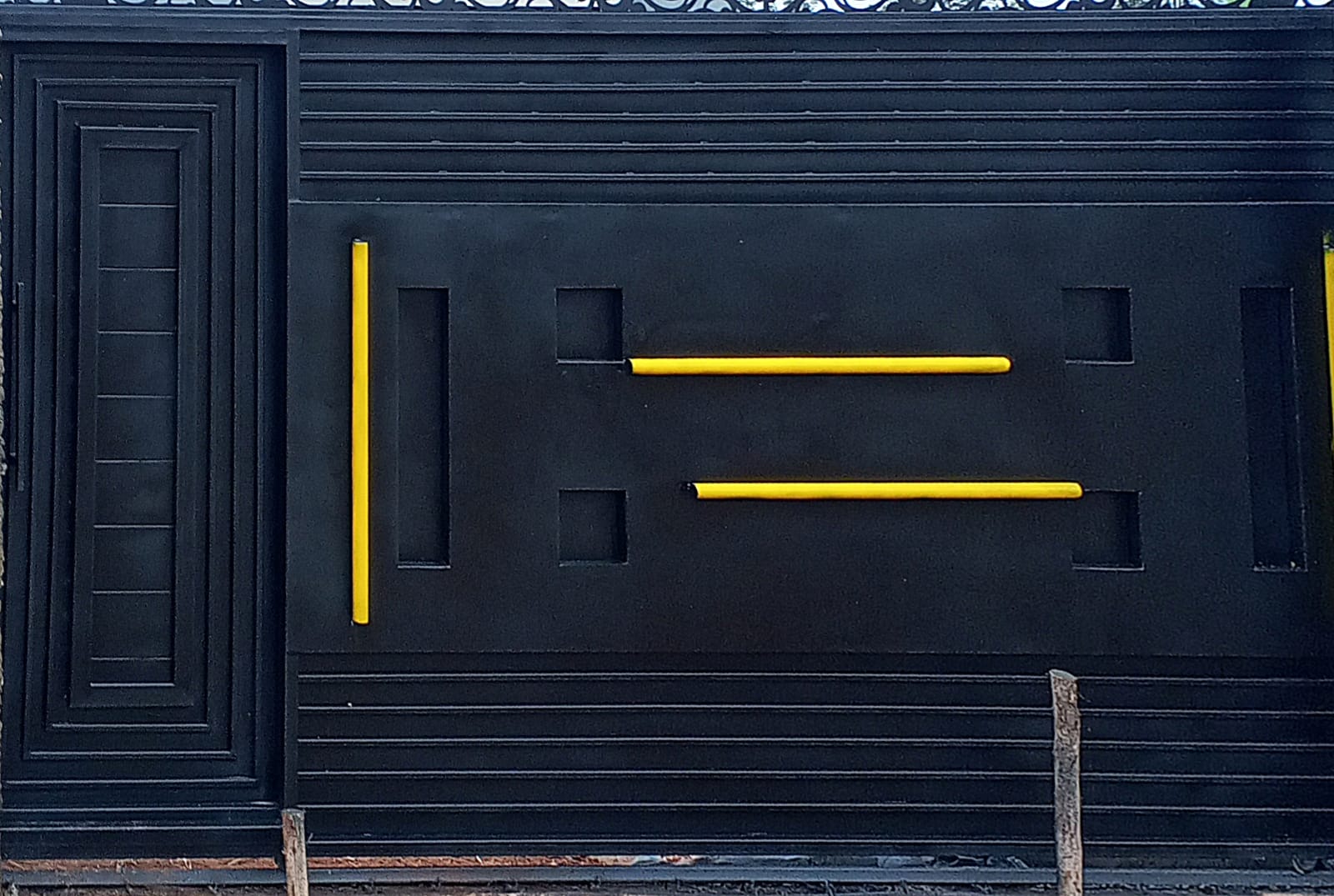 Black steel driveway gate with gold decorative details
